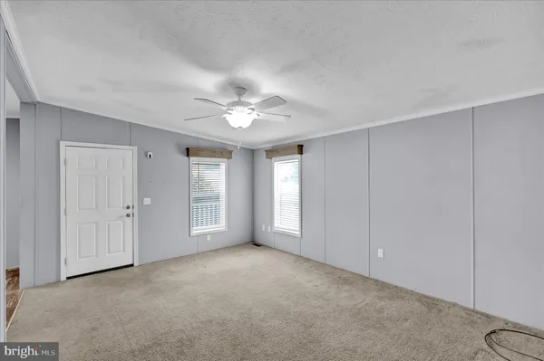 a view of an empty room with a chandelier fan