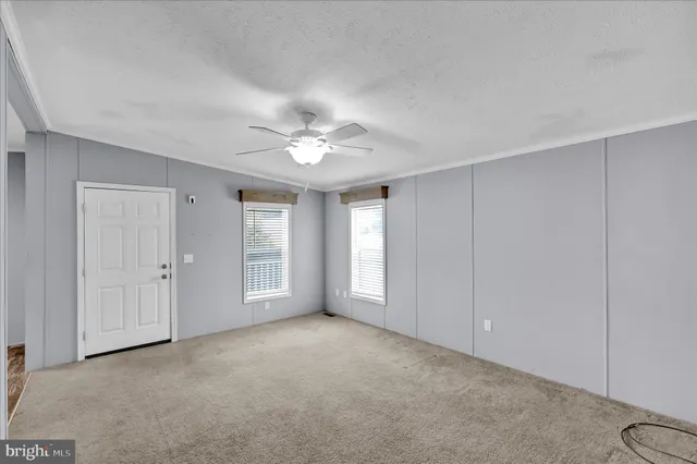 a view of an empty room with a chandelier fan