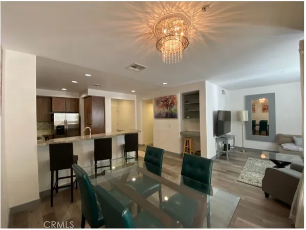 a view of a dining room with furniture a chandelier and wooden floor