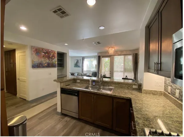 a kitchen with granite countertop a sink and a refrigerator
