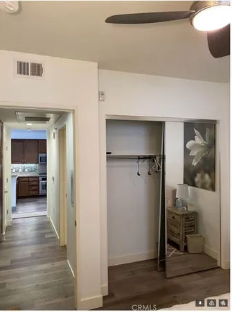 a view of a hallway with wooden floor and a living room
