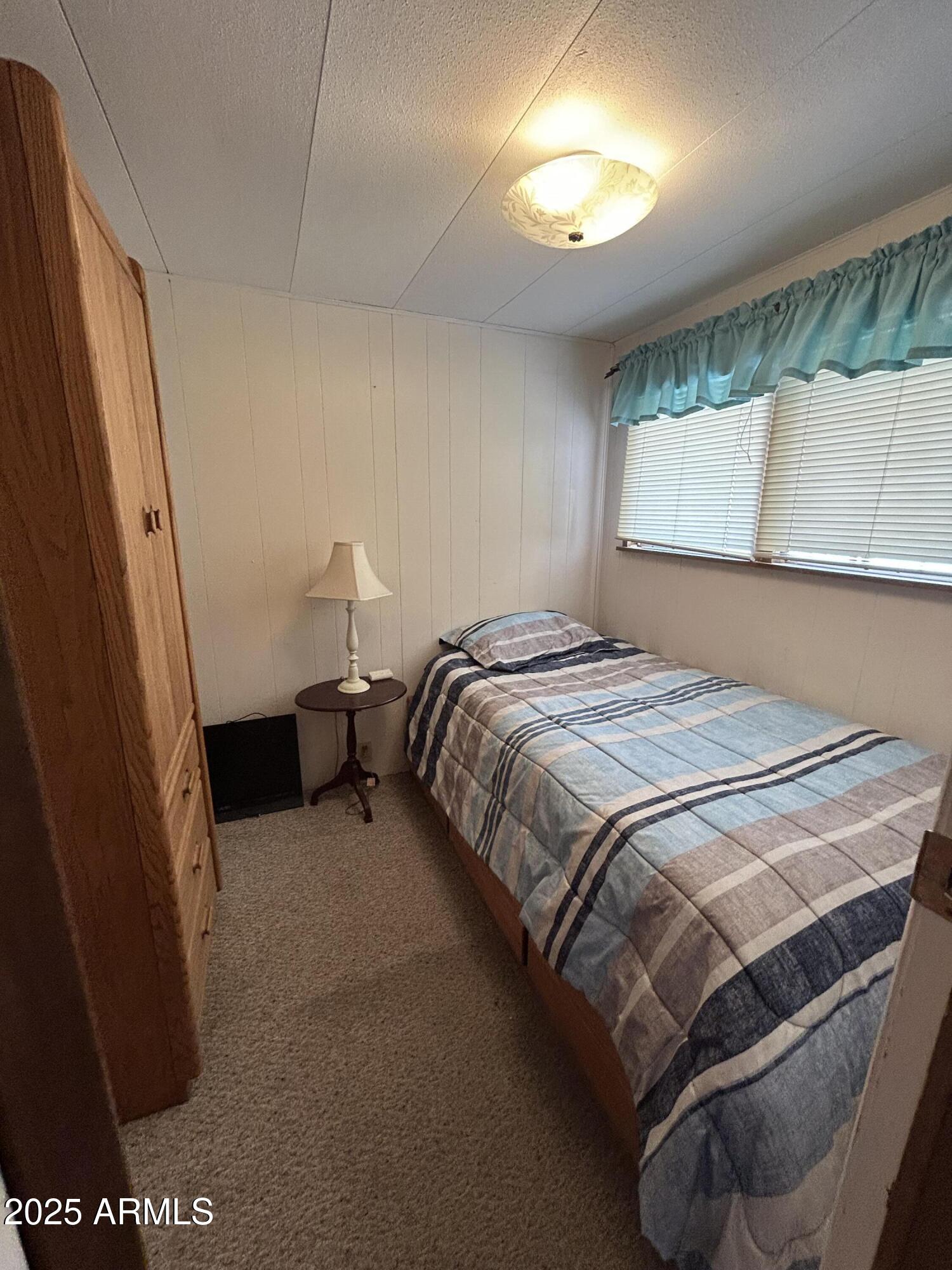 10220 East Apache Trail, Unit 28 Apache Junction, AZ 85120 - Photo 11 of 18 a bedroom with a bed and a window