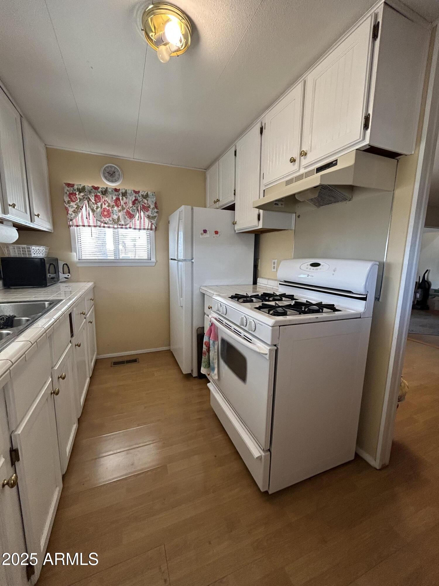 10220 East Apache Trail, Unit 28 Apache Junction, AZ 85120 - Photo 5 of 18 a kitchen with cabinets and steel stainless steel appliances
