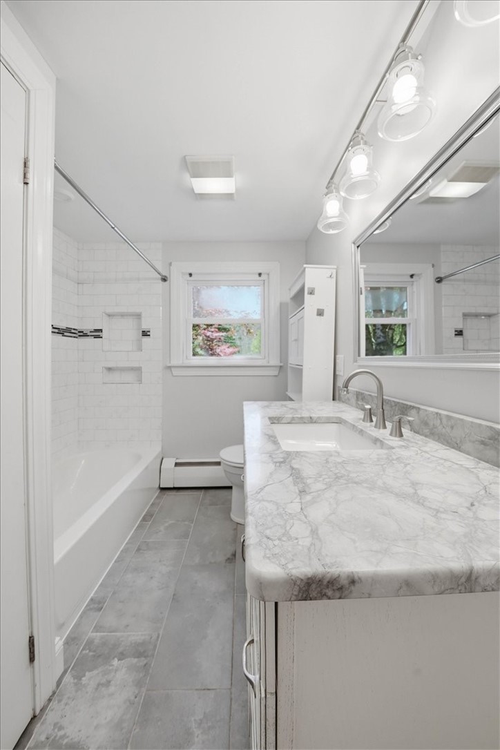 322 Rocky Hill Road Scituate, RI 02857 - Photo 34 of 50 Stunning renovated bath features a tiled bath/shower with storage niches marble vanity, stone tile flooring and modern lighting