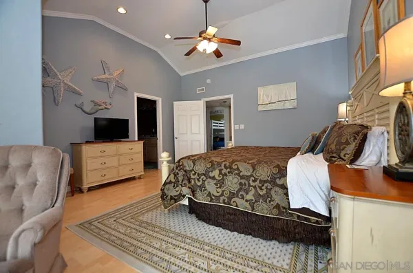a bedroom with a bed dresser and a flat screen tv