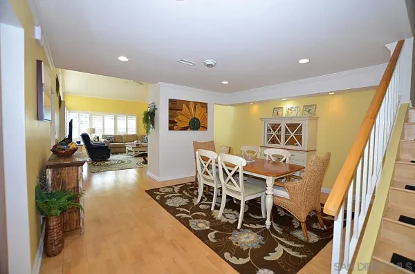 a view of a dining room with furniture a chandelier and wooden floor