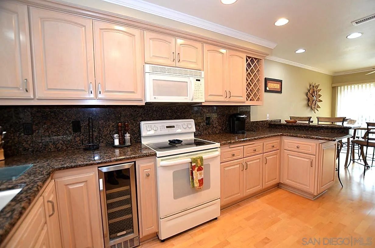 95 Port Of Spain Road Coronado, CA 92118 - Photo 7 of 40 a kitchen with granite countertop a sink stove top oven and cabinets