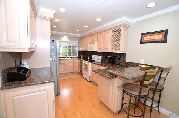 a kitchen with stainless steel appliances granite countertop a stove a sink and a microwave