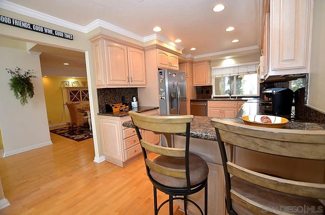 95 Port Of Spain Road Coronado, CA 92118 - Photo 9 of 40 a kitchen with stainless steel appliances kitchen island granite countertop a table chairs and a refrigerator