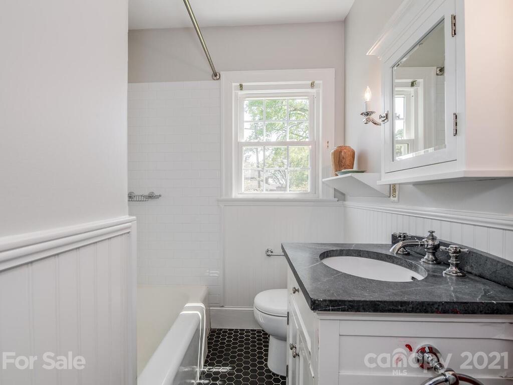 1408 Lilac Road Charlotte, NC 28209 - Photo 13 of 23 a bathroom with a granite countertop sink a mirror and a toilet