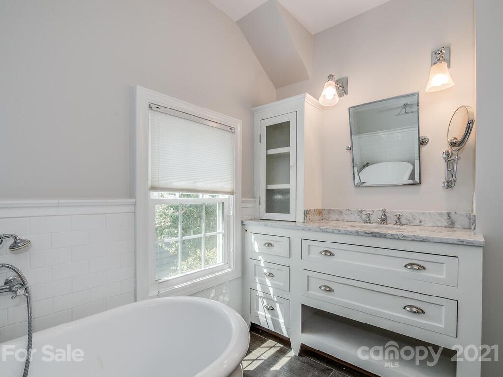 1408 Lilac Road Charlotte, NC 28209 - Photo 18 of 23 a bathroom with a bathtub a sink and a window