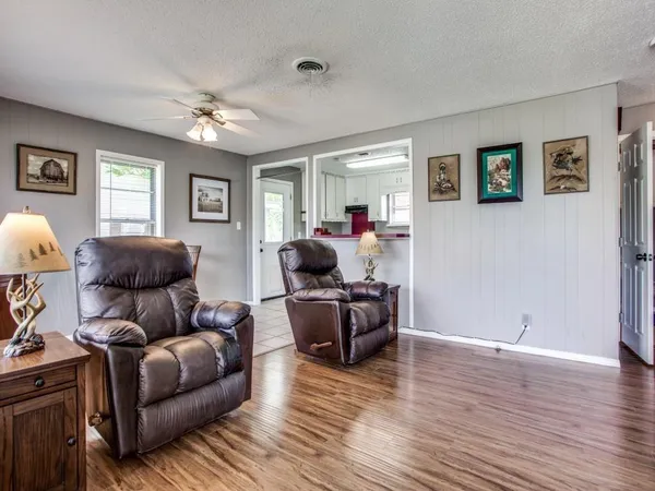 a living room with furniture and a wooden floor
