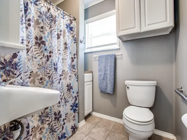a bathroom with a toilet and a shower curtain