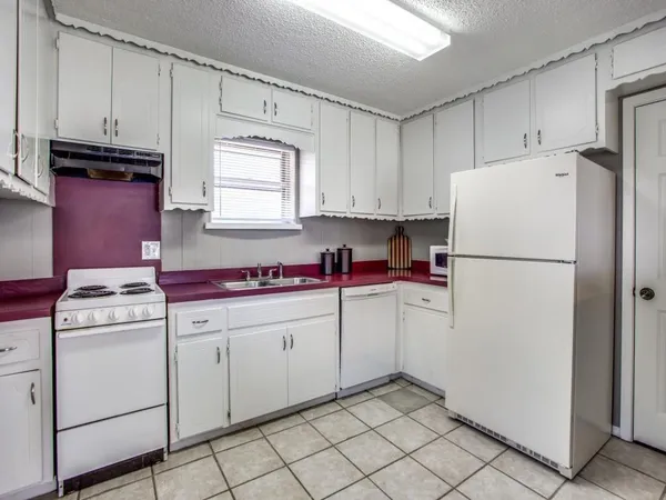a kitchen with cabinets a refrigerator and a sink