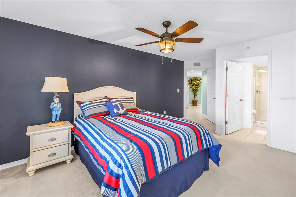 16326 Gulf Boulevard, Unit 308 Redington Beach, FL 33708 - Photo 24 of 44 a bedroom with a bed and a chandelier