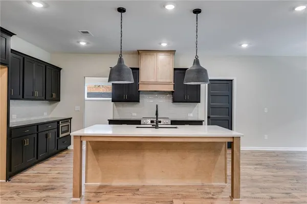 a kitchen with stainless steel appliances granite countertop a sink a microwave a refrigerator and a stove