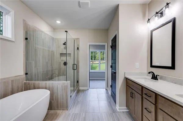 a bathroom with a double vanity sink a large mirror a shower and bathtub