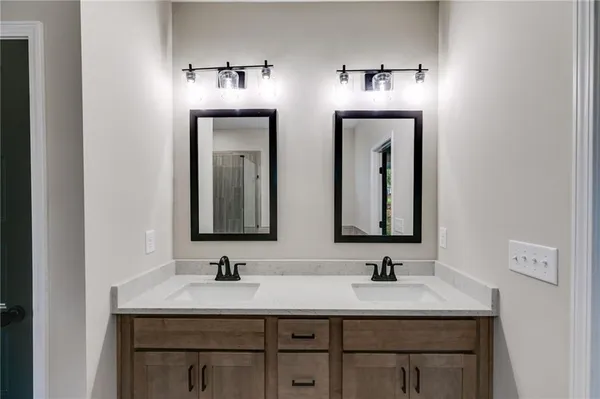 a bathroom with double sink and a mirror