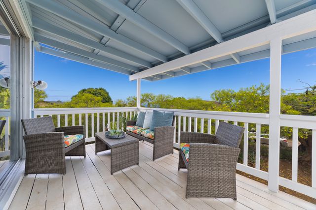 a view of a chair and tables in the balcony