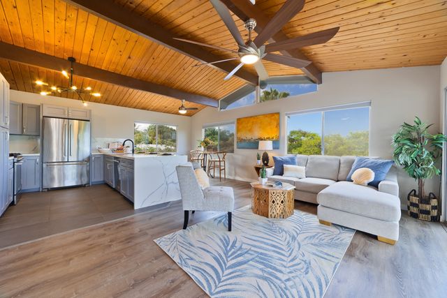 a living room with lots of furniture and view of kitchen