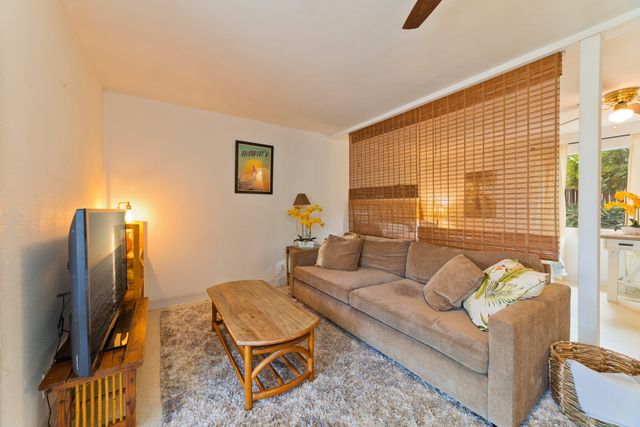 a living room with furniture a flat screen tv and a window