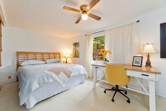 a bedroom with a bed a desk and a chandelier