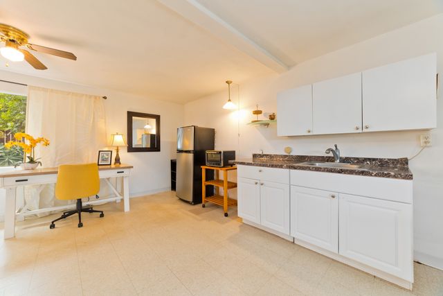 a open hall with stainless steel appliances granite countertop a stove and a sink