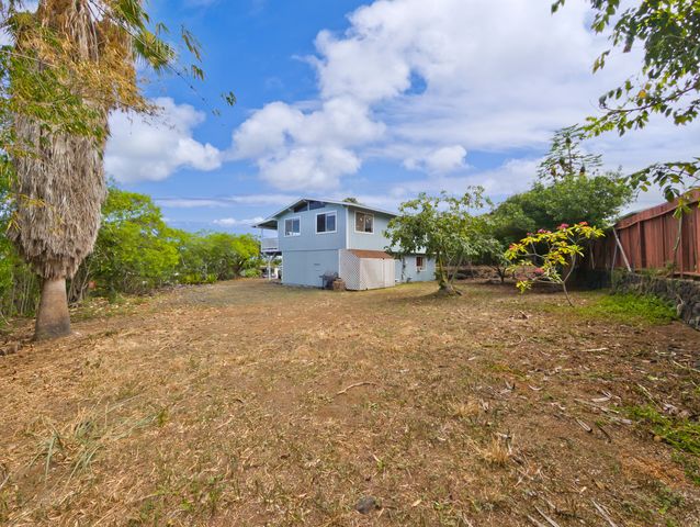 a view of a house with a yard and wooden fence