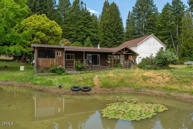 a front view of house with yard and lake view
