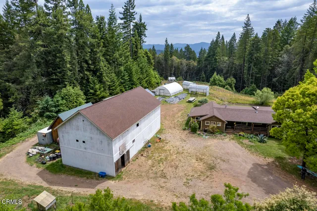 an aerial view of a house with yard and lake view