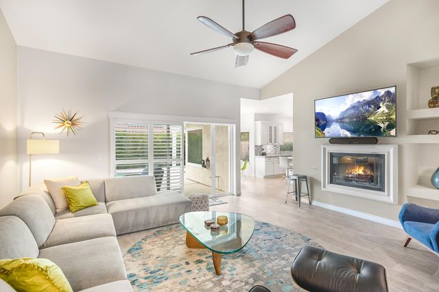 a living room with furniture a flat screen tv and a fireplace