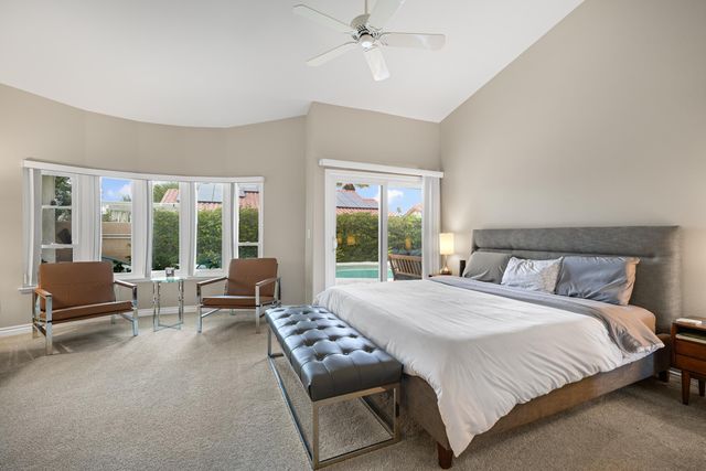 a bedroom with a bed and large windows