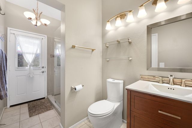 a bathroom with a toilet a sink a mirror a vanity and shower