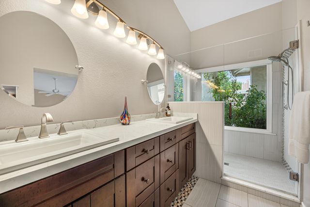 a en suite bathroom with a double vanity sink and a mirror