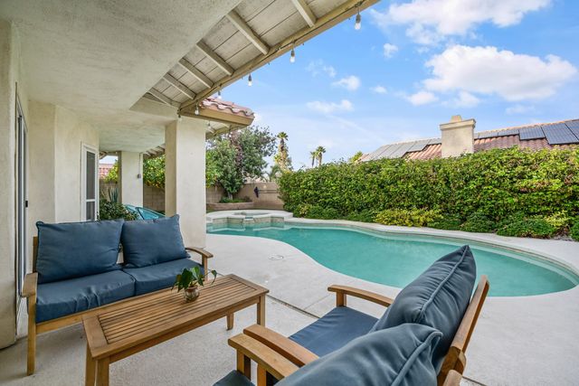 a view of a patio with couches table and chairs with potted plants
