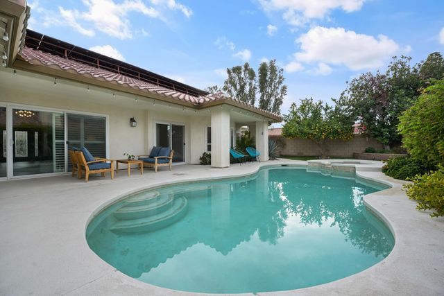 a view of a house with swimming pool and sitting area