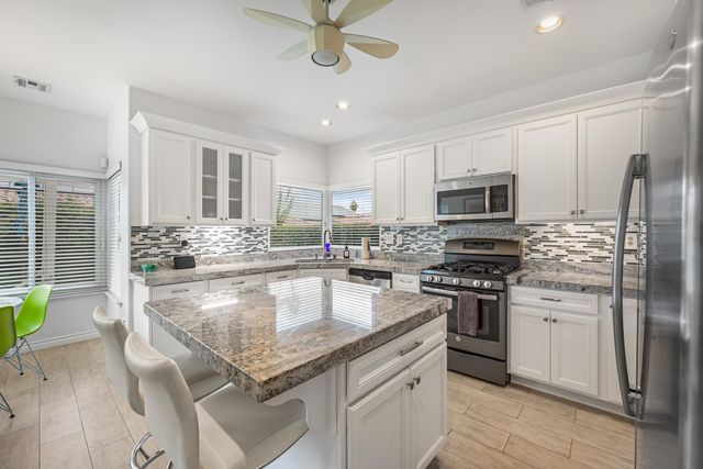 a kitchen with stainless steel appliances granite countertop a stove refrigerator and microwave