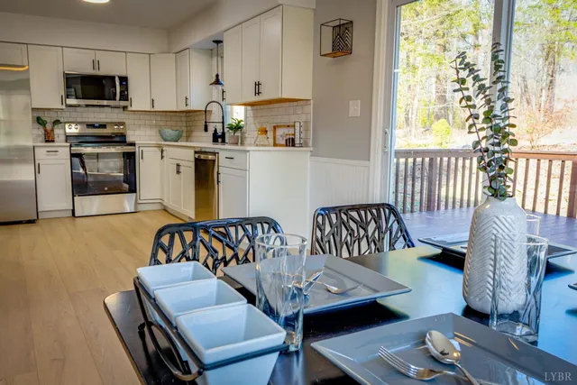 a kitchen with stainless steel appliances granite countertop a refrigerator a stove and a sink with wooden floor