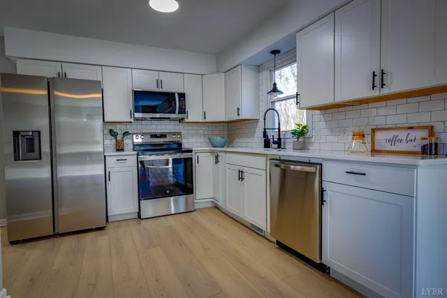 a kitchen with stainless steel appliances granite countertop white cabinets stove a sink and dishwasher