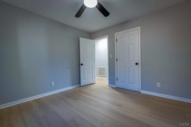 a spacious bedroom with a bed and a chandelier