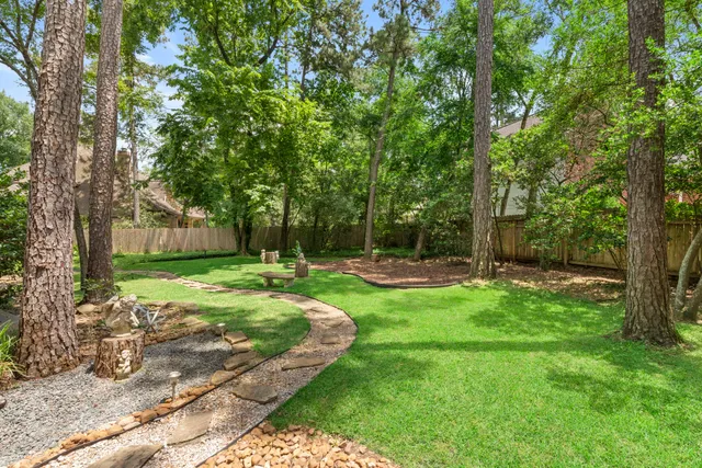 a front view of a house with a garden and trees