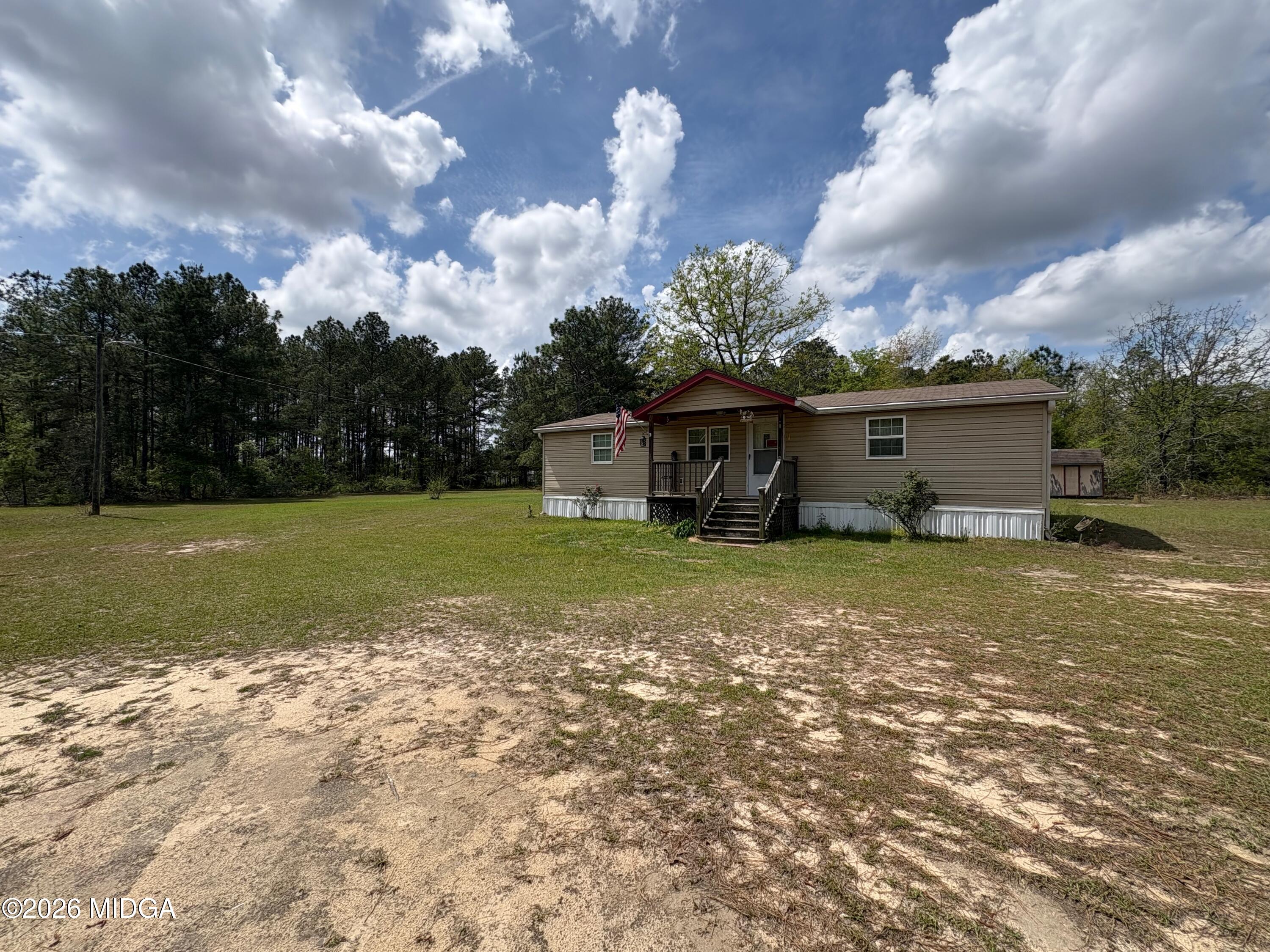 346 Quail Run Road Roberta, GA 31078 - Photo 15 of 15 a view of a house with a yard and a large tree