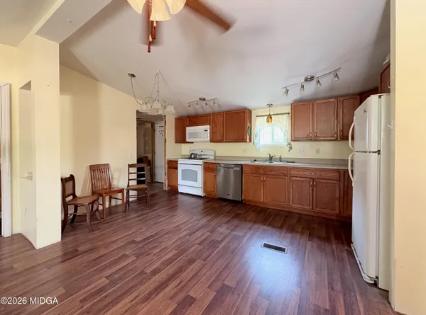 a kitchen with stainless steel appliances a microwave a stove a sink dishwasher and a refrigerator with wooden floor