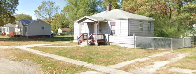 a view of a house with a yard and large tree