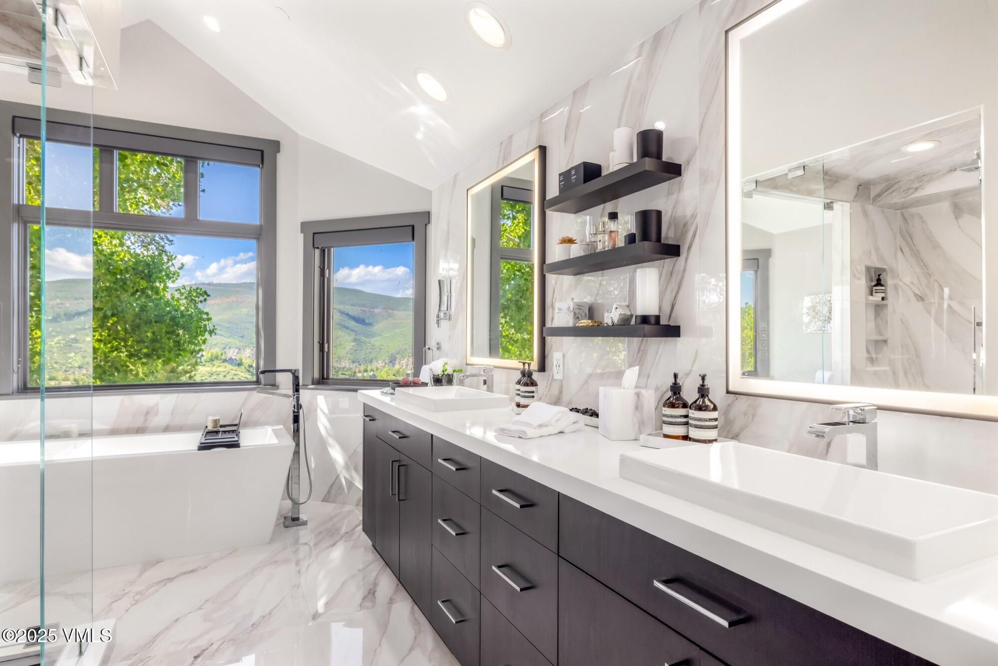 25 West Timber Drive Edwards, CO 81632 - Photo 27 of 55 a bathroom with double vanity sinks a large mirror and a bathtub next to a window
