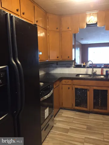 a kitchen with stainless steel appliances granite countertop a refrigerator a sink dishwasher a stove and a microwave oven on table