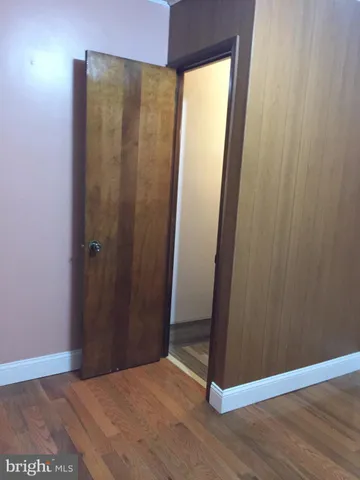 an empty room with wooden floor and closet