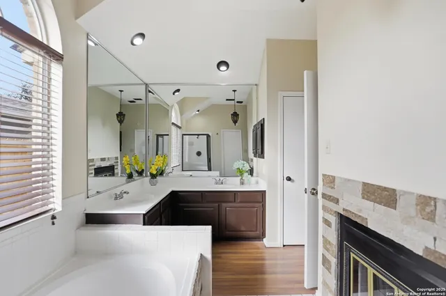 a spacious bathroom with a tub sink and mirror