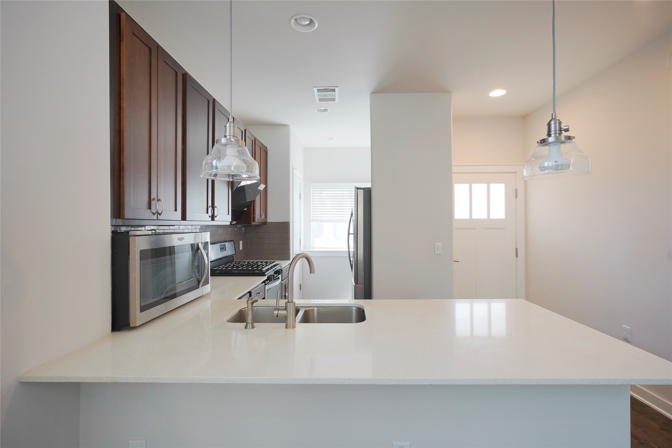 8945 Parker Ranch Circle, Unit A Austin, TX 78748 - Photo 3 of 25 a kitchen with a sink dishwasher a stove and a refrigerator with wooden floor