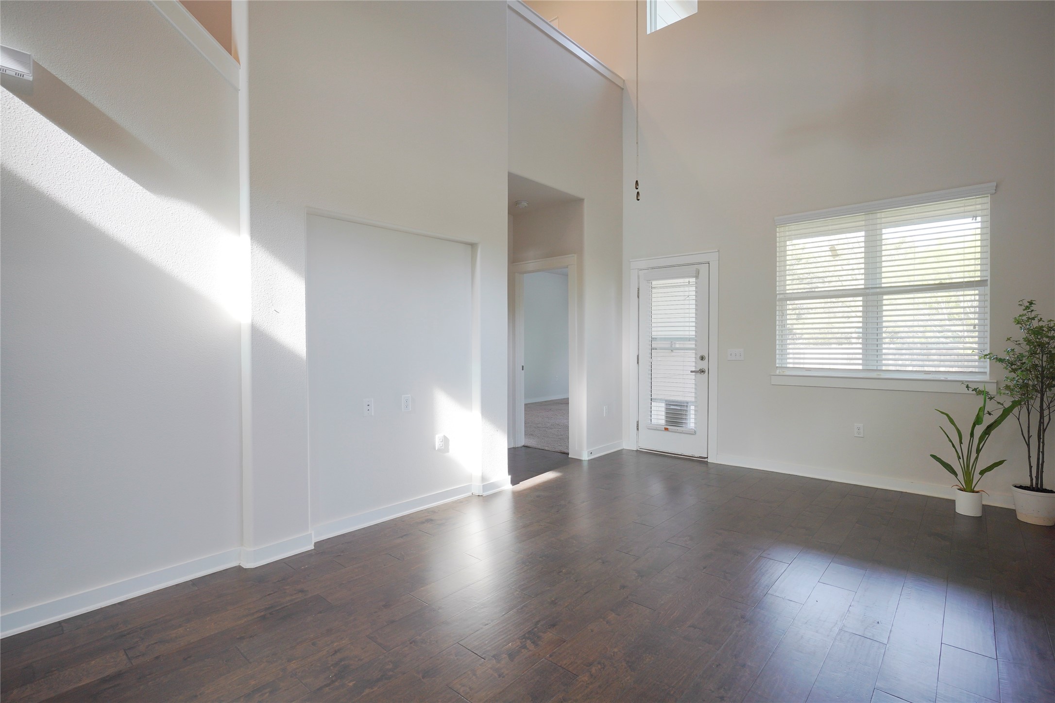 8945 Parker Ranch Circle, Unit A Austin, TX 78748 - Photo 9 of 25 an empty room with wooden floor and windows with curtains